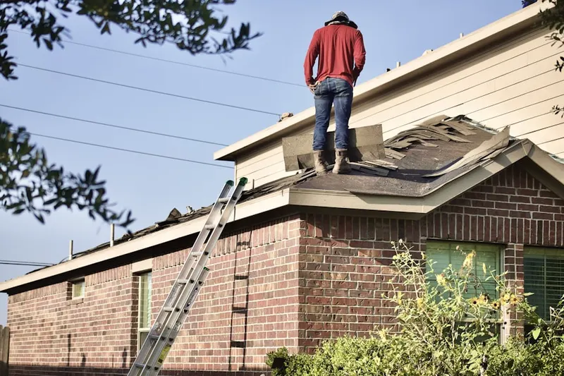 Professional roofer working on a residential roof in Troon Village